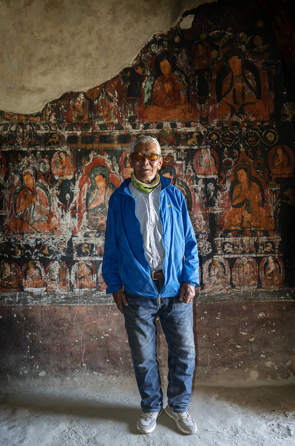 5月26日，仁增旺扎老人在皮央石窟的壁画前留影。新华社记者 费茂华 摄