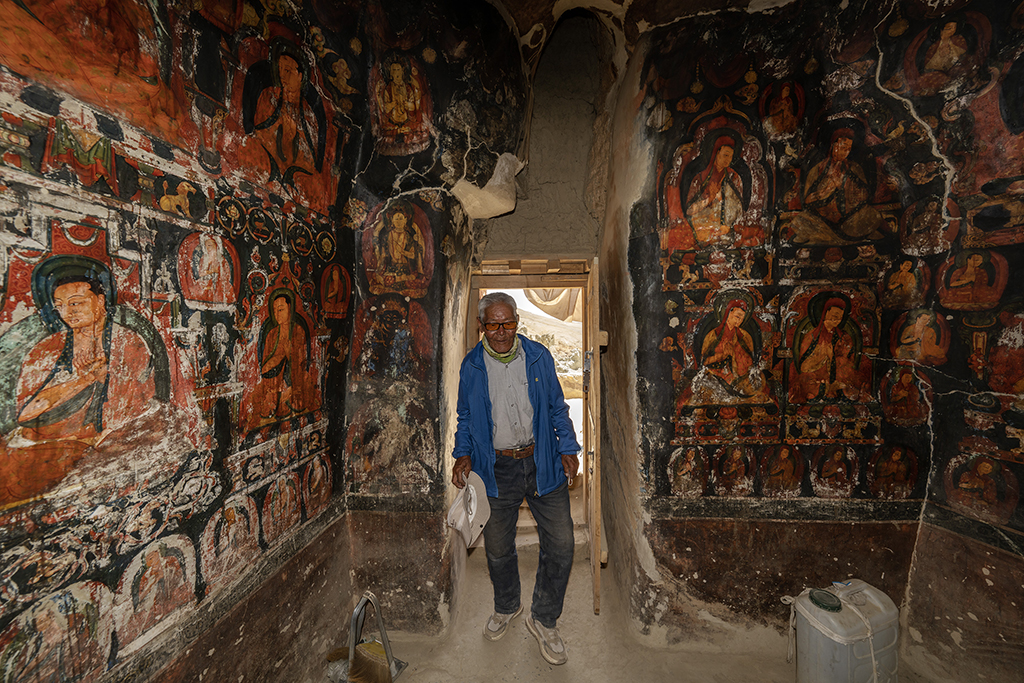 5月26日，仁增旺扎老人走进绘满壁画的石窟。新华社记者 费茂华 摄