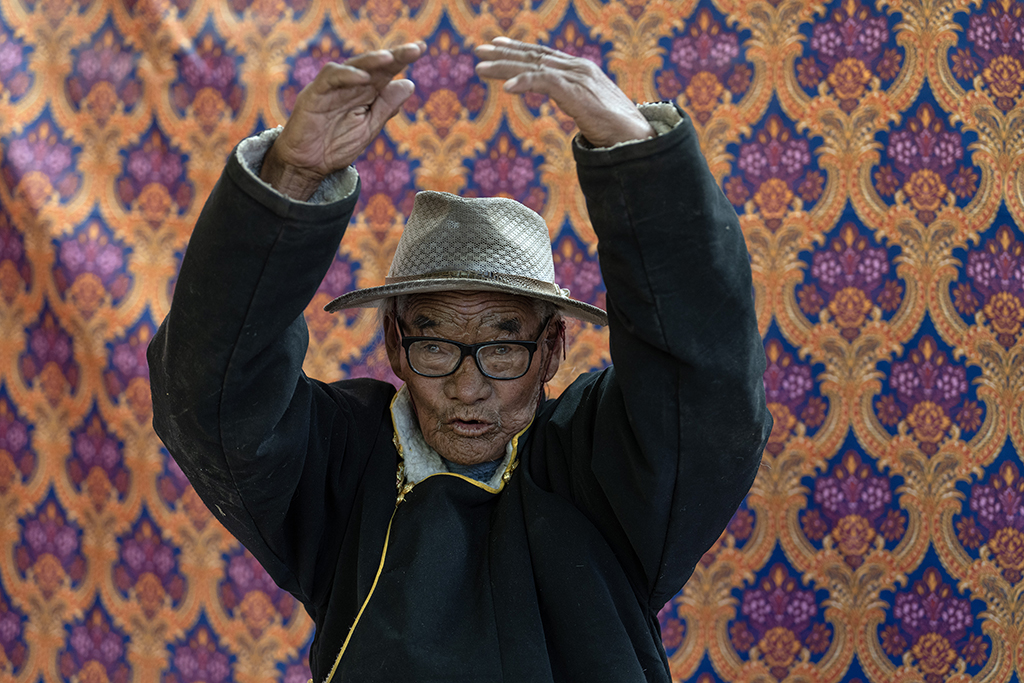 5月28日，洛桑占堆老人在自己现在居住的第四个家，也是典角村的“三代房”里向记者讲述自己的人生故事。新华社记者 费茂华 摄
