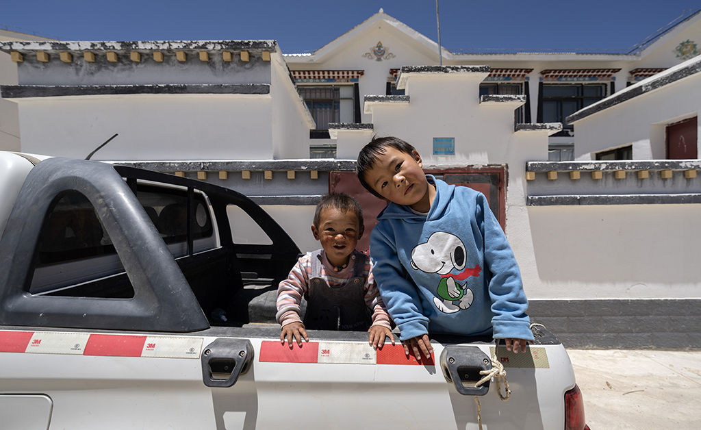 5月28日，洛桑占堆老人的重孙子次仁顿珠（右）和扎西尼玛在自己居住的典角村“五代房”外面玩耍。新华社记者 费茂华 摄
