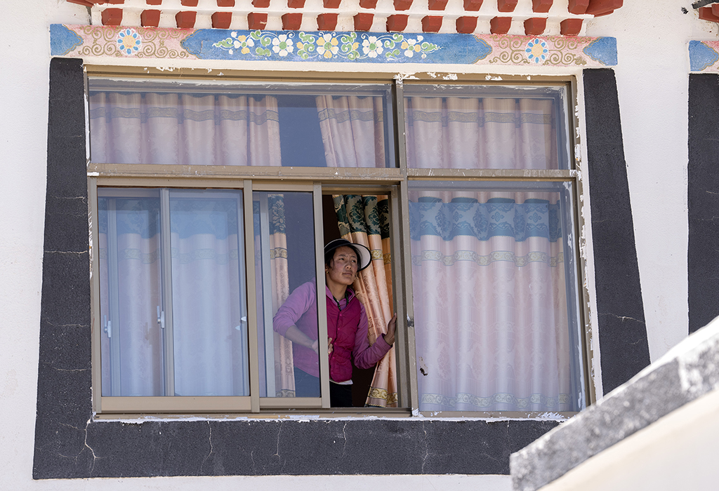 5月28日，洛桑占堆老人的孙媳妇白玛尼珍在自己居住的典角村“五代房”里向远处�t望。新华社记者 费茂华 摄