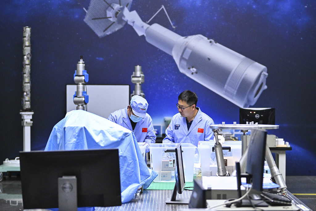 中国科学院空间光学系统在轨制造与集成重点实验室副主任徐振邦（右）与同事在实验室内进行科研工作（5月25日摄）。新华社记者 许畅 摄