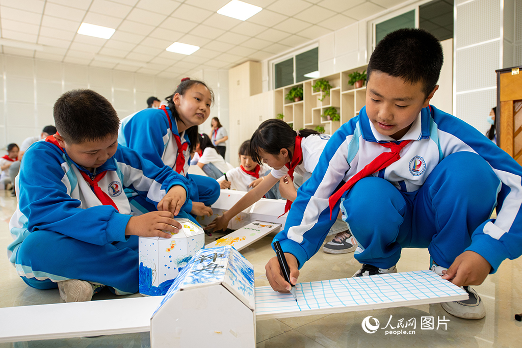 5月29日，在中国酒泉卫星发射中心东风小学，学生们正在自制拼装空间站模型，寓教于乐，学习航天知识。人民网记者 翁奇羽摄