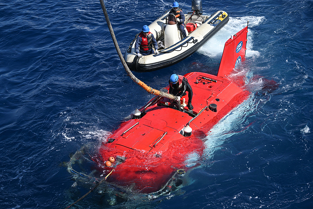 潛航員為“深海勇士”號載人潛水器解開與“探索一號”科考船相連的纜繩，為“深海勇士”號載人潛水器下潛做准備（5月26日攝）。新華社記者 蒲曉旭 攝