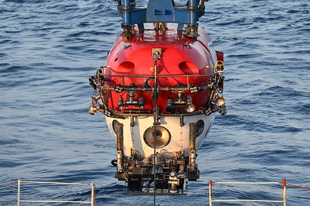 搭載著考古隊員的“深海勇士”號載人潛水器從“探索一號”科考船下放至海面，即將下潛開始當日的水下調查（5月24日攝）。新華社記者 蒲曉旭 攝