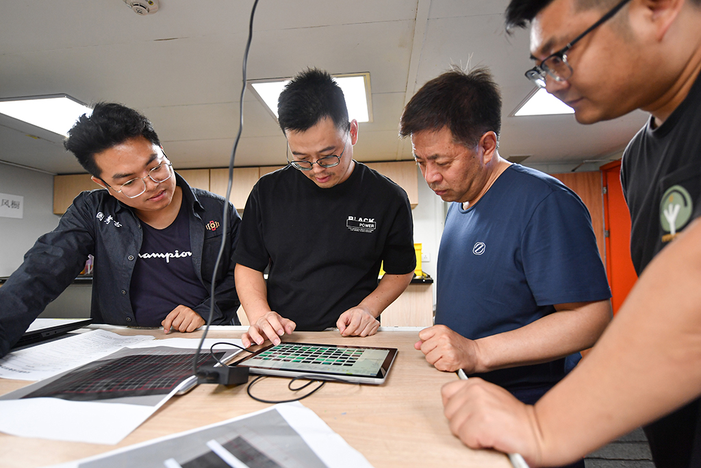 考古隊員在“探索一號”科考船上查看從水下採集的考古數據（5月24日攝）。新華社記者 蒲曉旭 攝