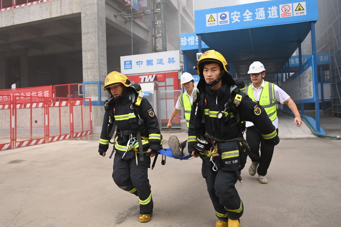 6月6日，參加消防應急演練的救援人員將“傷員”抬往救護車。