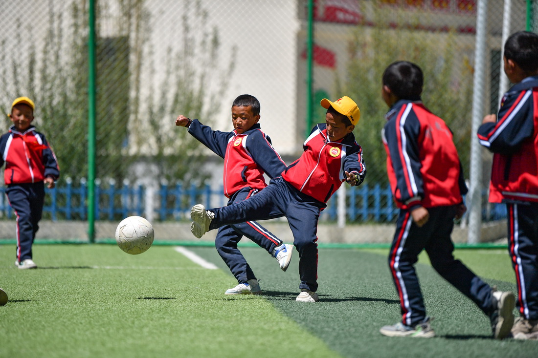 扎西宗鄉完全小學的學生在人工草坪上踢足球（6月5日攝）。新華社記者 晉美多吉 攝