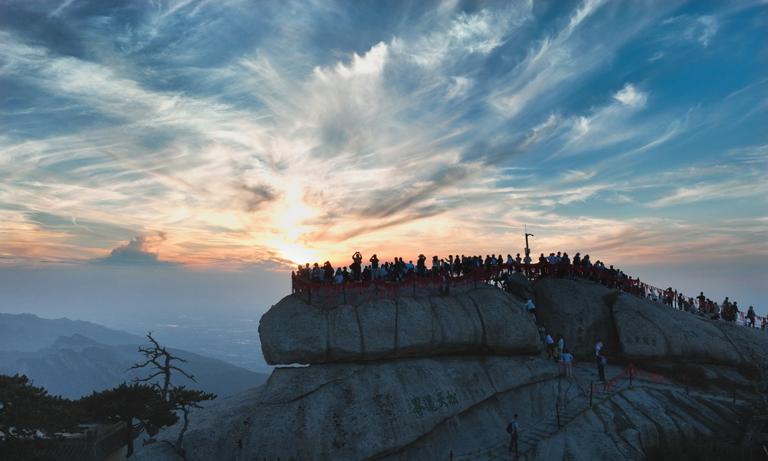 6月23日，游客在华山西峰观赏落日（无人机照片）。
