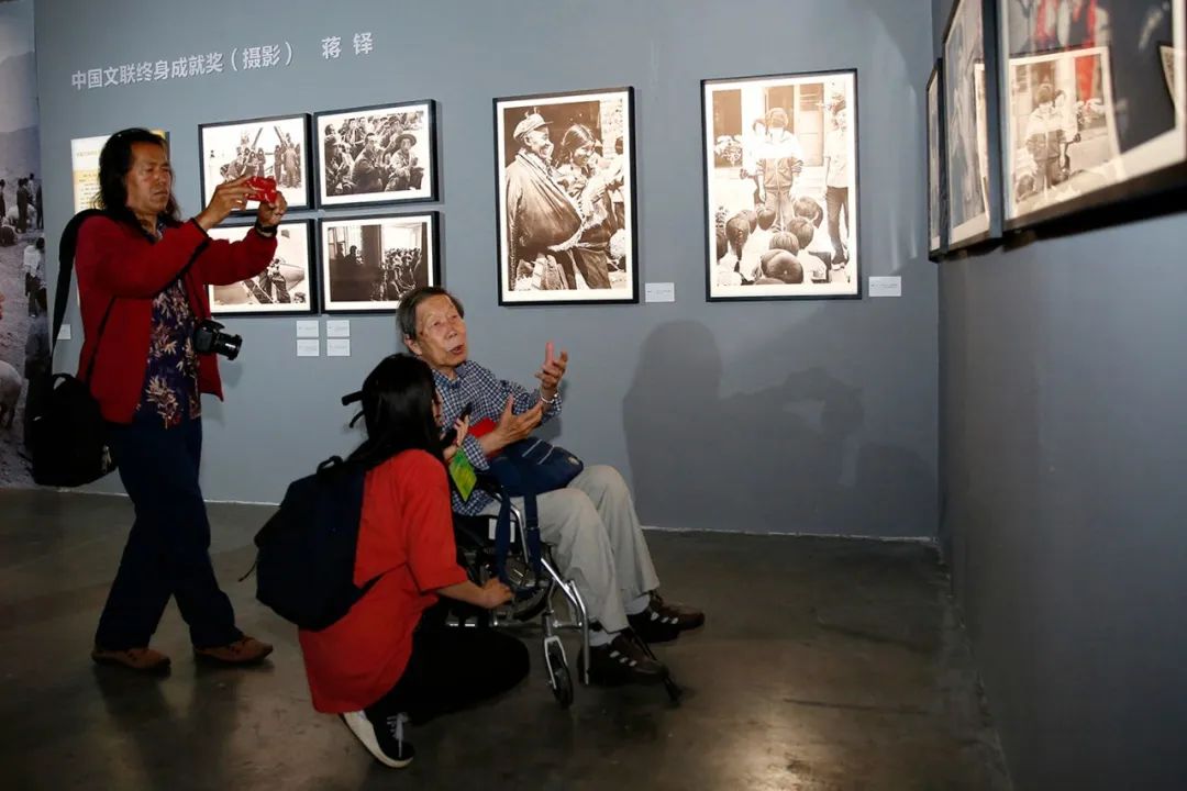 中國文聯終身成就獎（攝影）獲得者蔣鐸在展覽現場與觀眾交流。張雙雙攝