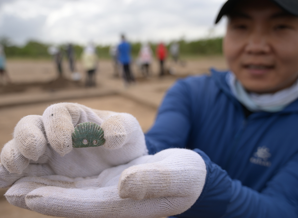 7月5日，考古隊工作人員展示一件在遺址現場採集的文物。新華社記者 李賀 攝