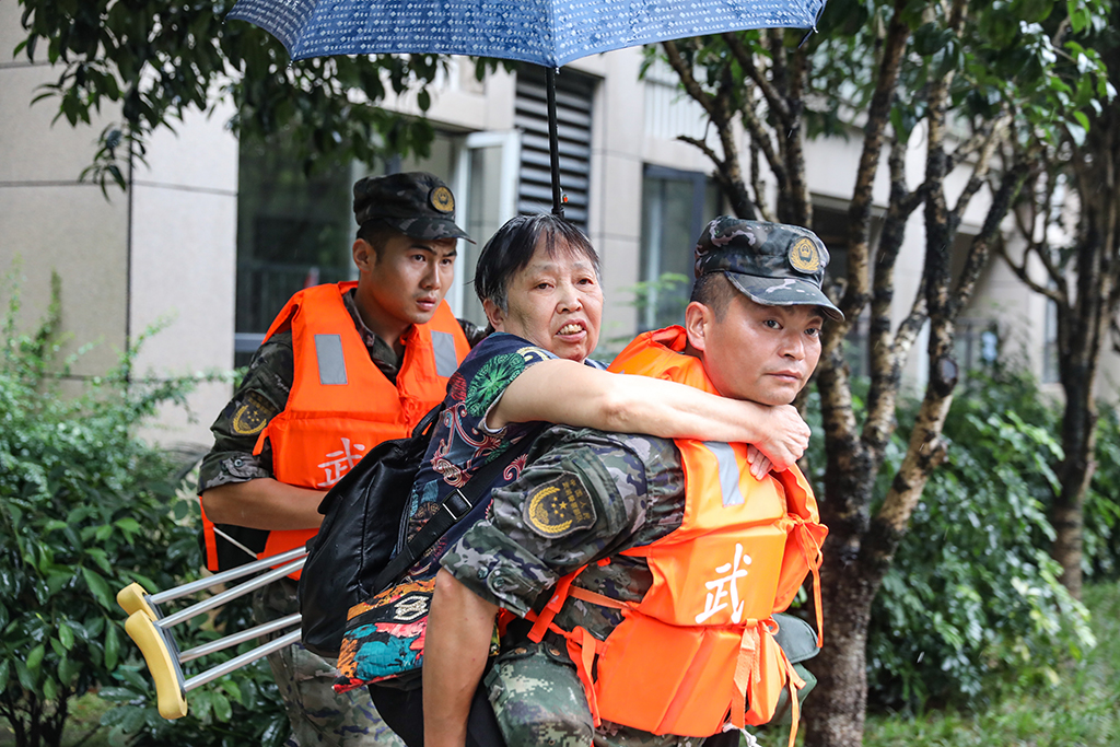 7月14日，在重庆市万州区江南新区，武警重庆总队执勤第三支队官兵在转移群众。新华社发（黄�S 摄）