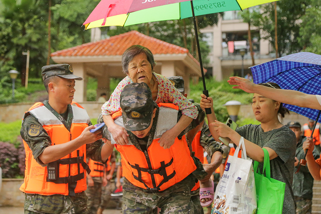 7月14日，在重慶市萬州區江南新區，武警重慶總隊執勤第三支隊官兵在轉移群眾。新華社發（黃赟 攝）