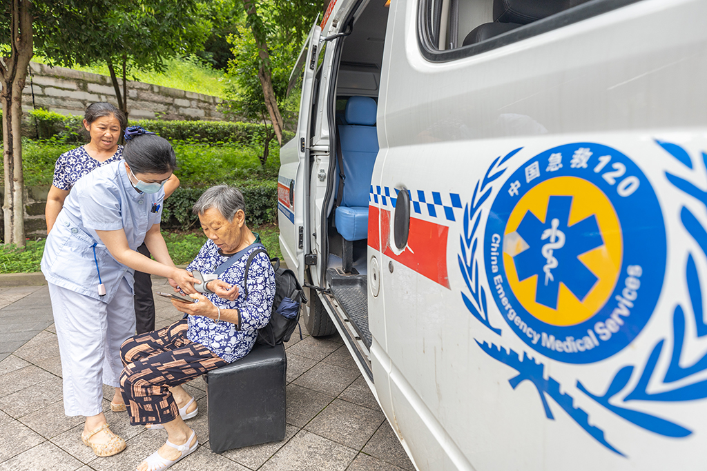 7月14日，在重慶市萬州三中江南校區臨時安置點內，醫護人員為轉移安置人員測量血壓。新華社記者 黃偉 攝