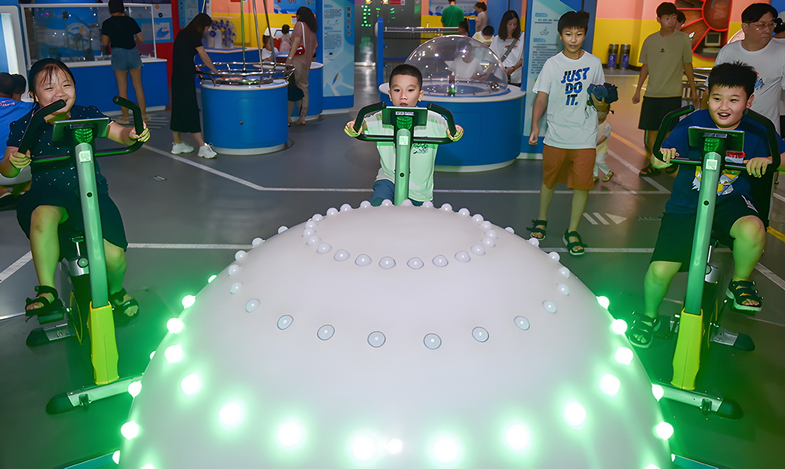 7月29日，小朋友在河南省洛陽市科技館參觀體驗“人力發電”科普設備。新華社發（黃政偉 攝）