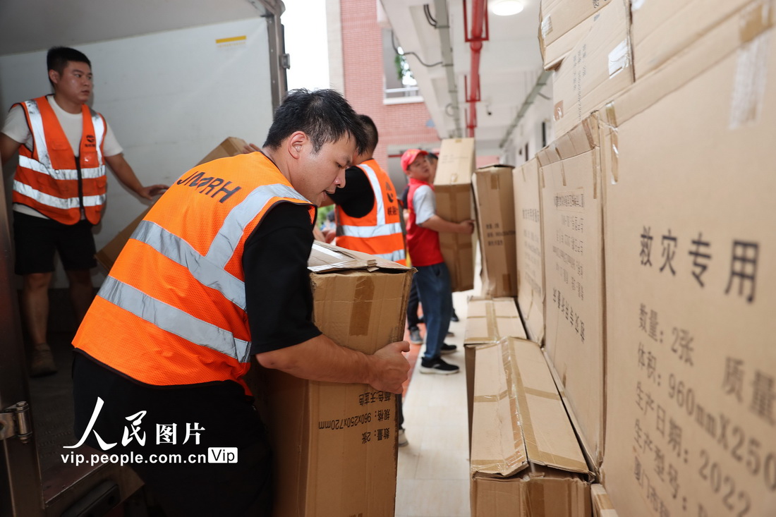 7月29日，在福建省廈門市新圩學校臨時安置點，志願者在搬運物資。