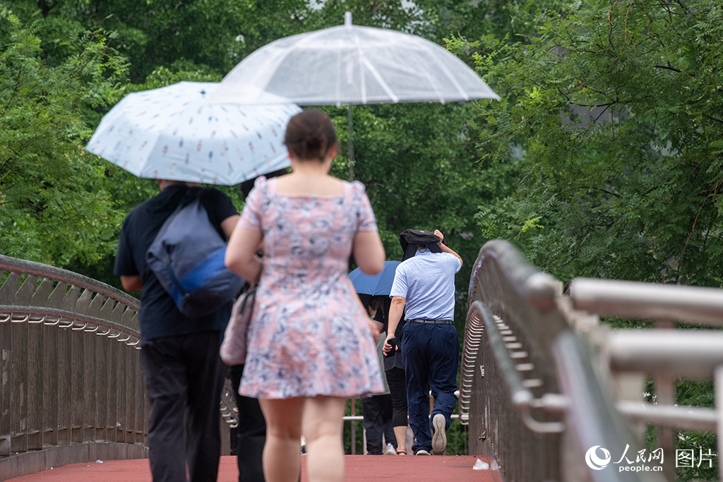 7月31日，北京市民冒雨出行。