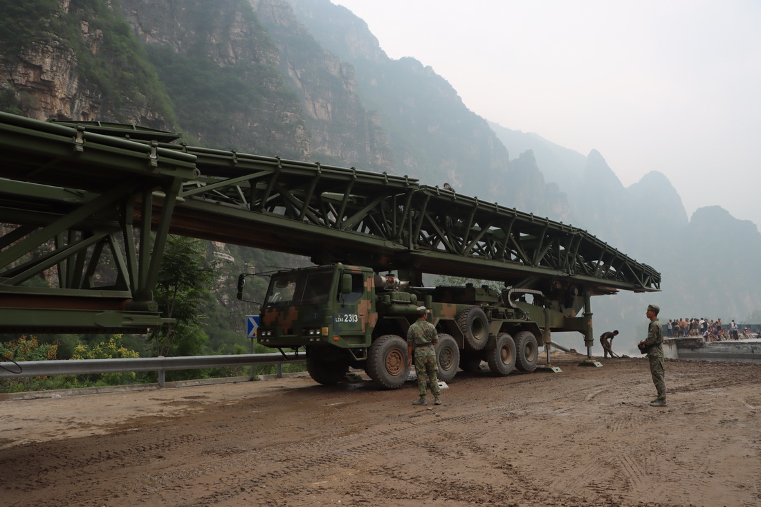 8月3日，中部戰區陸軍第82集團軍某旅官兵在北京市房山區淶寶路四渡橋斷橋處架設橋梁。新華社發（張康 攝）