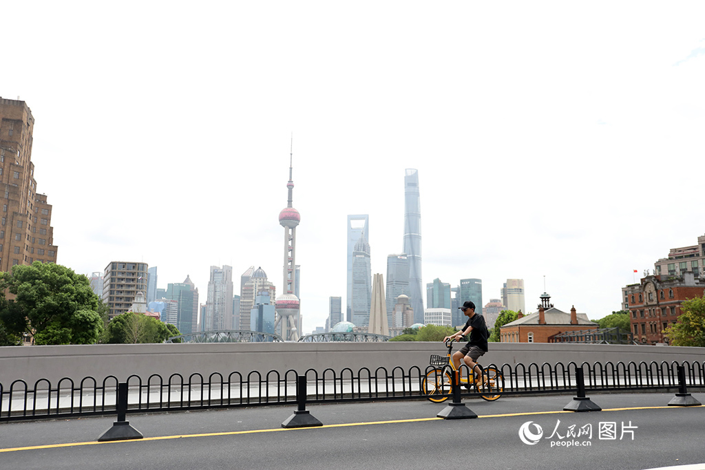 8月14日，一位市民骑共享单车路过上海外滩。“节能降碳”在上海不再是一个概念，它已经融入上海人的工作生活场景中。“单车慢行，逛游上海”成了很多年轻游客初遇沪上的方式，上下班骑车转乘地铁公交则融入了上班族的日常生活。人民网记者 龚莎摄