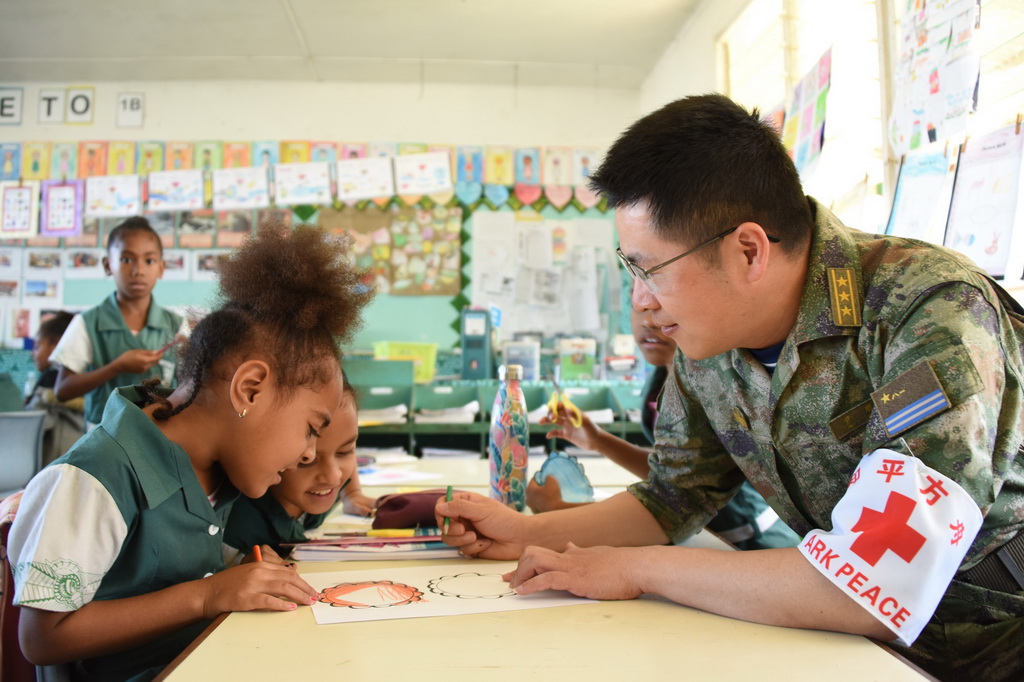 8月11日，中国海军“和平方舟”号人员在瓦努阿图一所学校同学生一起画画。新华社记者 黎云 摄
