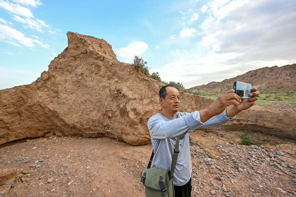 8月20日，董海寧巡查賀蘭山沿線的明長城永寧段時用手機拍照記錄。新華社記者 連振 攝