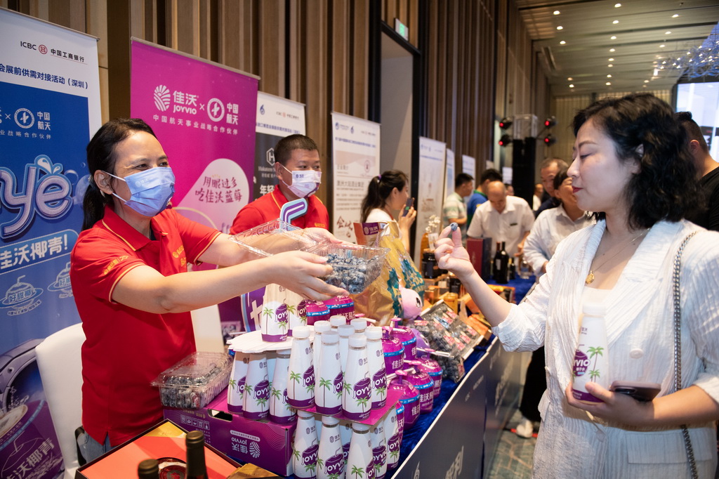 8月29日，在深圳举行的进博会展前供需对接活动上，参展商（左）向采购商介绍进口蓝莓。