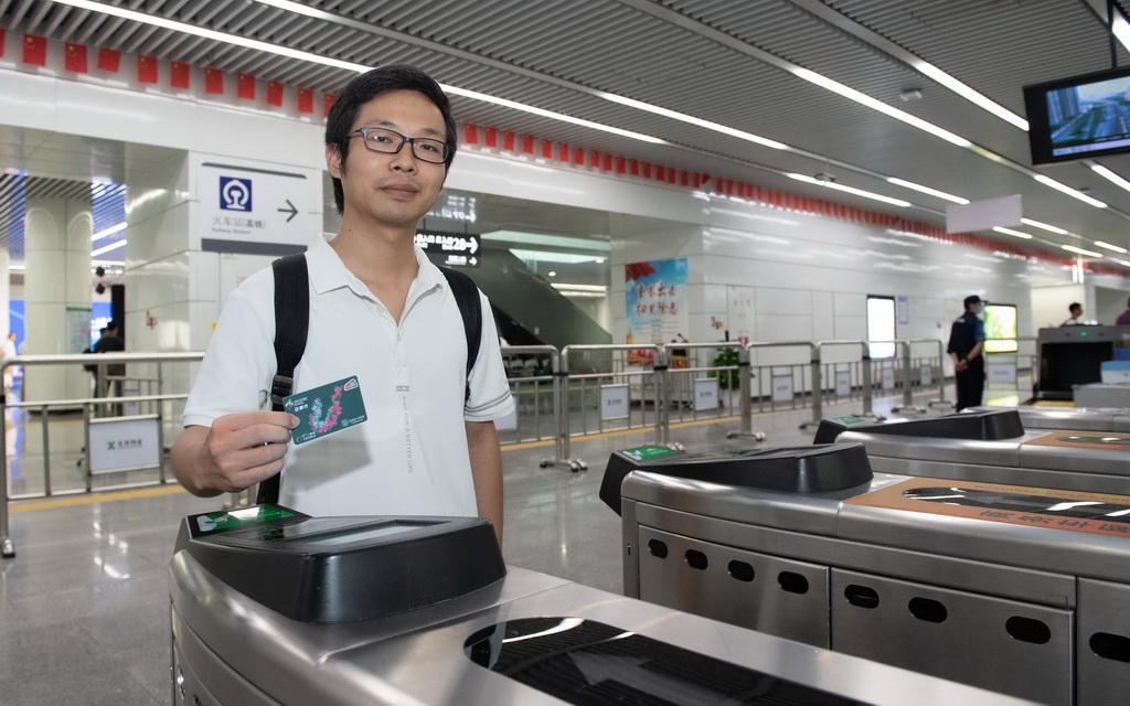 8月30日，在深圳福田站地铁闸机入口，用户持深港互通行卡准备刷卡。新华社记者 毛思倩 摄
