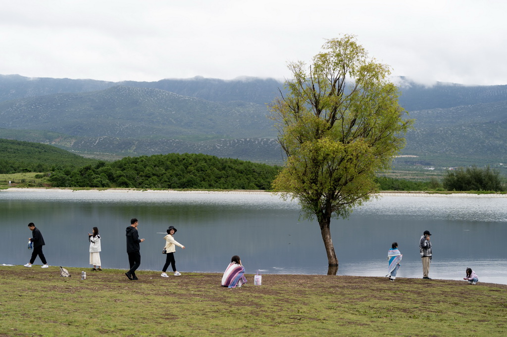 游客在麗江市玉龍納西族自治縣白沙鎮玉湖村龍女湖邊休閑游玩（8月28日攝）。