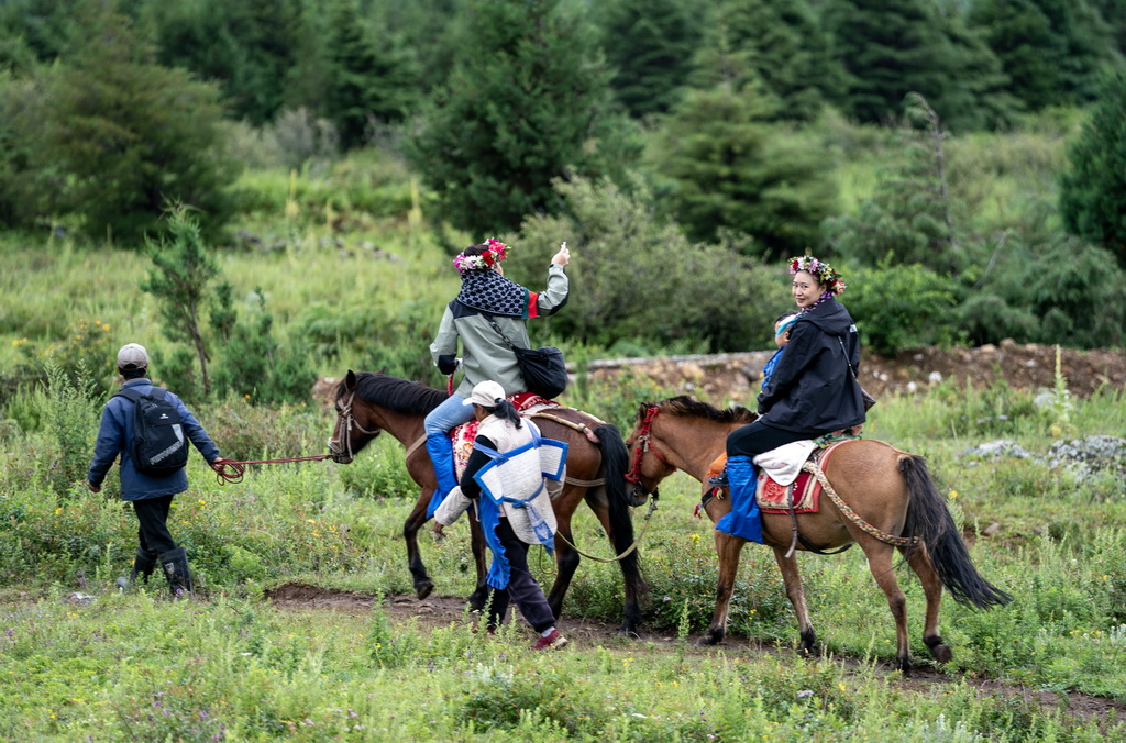 游客在麗江市玉龍納西族自治縣白沙鎮玉湖村體驗騎馬（8月28日攝）。