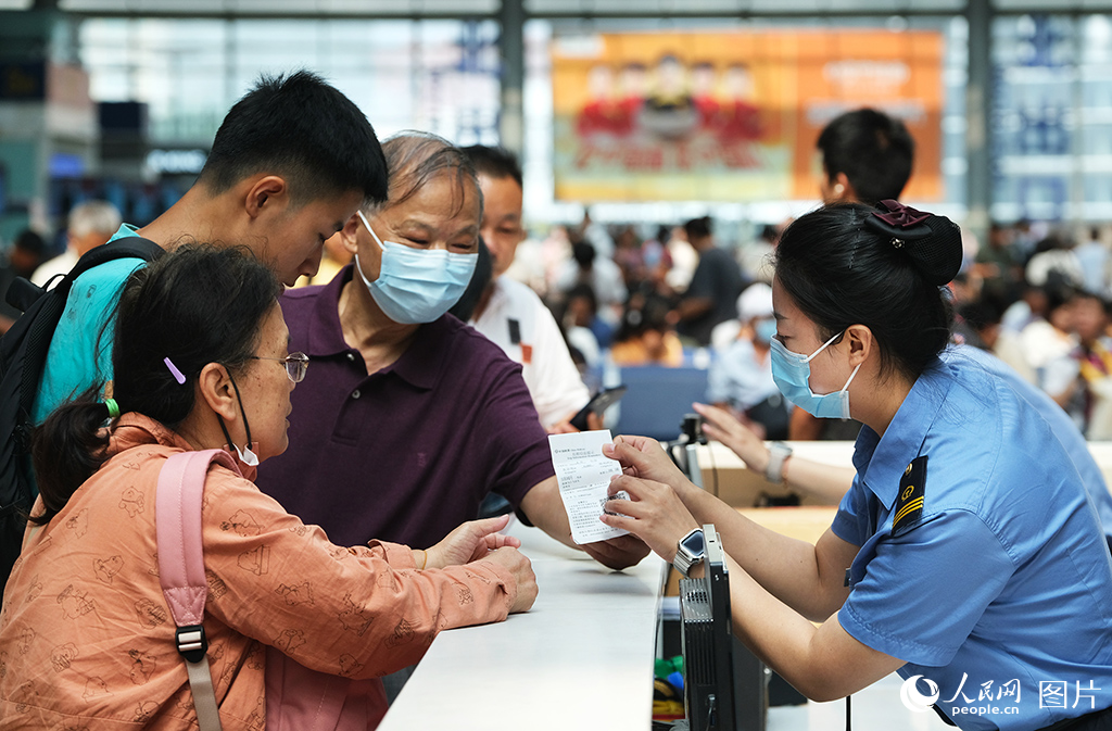 8月31日，北京南站候車大廳服務人員正在為旅客提供問詢服務。
