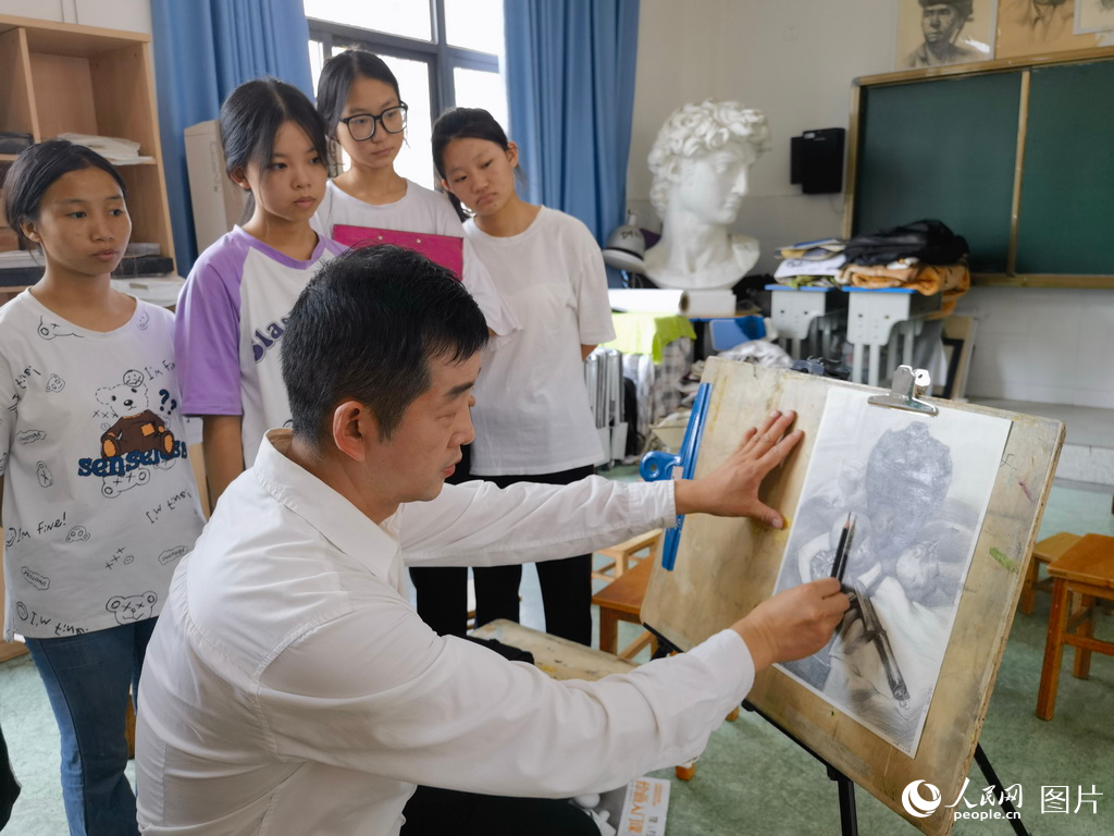 近日，武汉市第一聋哑学校特教老师甘云山正在给聋哑学生上美术课。人民网 周雯摄