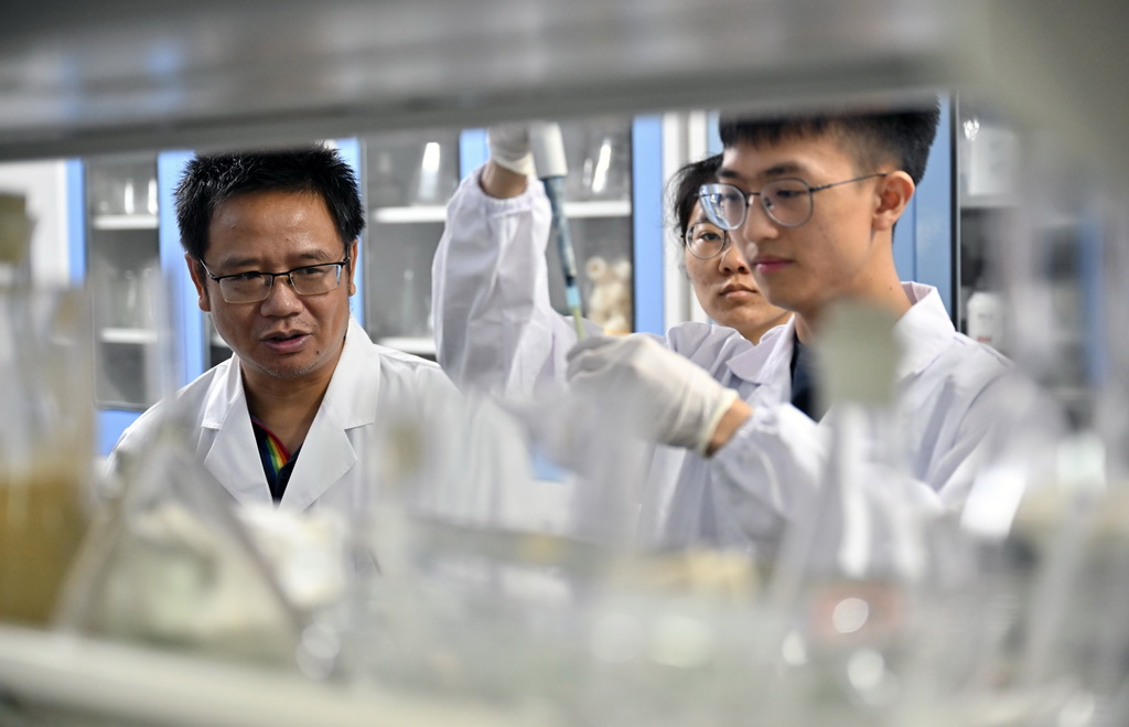 9月8日，曾念開（左一）在海南醫學院和學生一起做實驗。