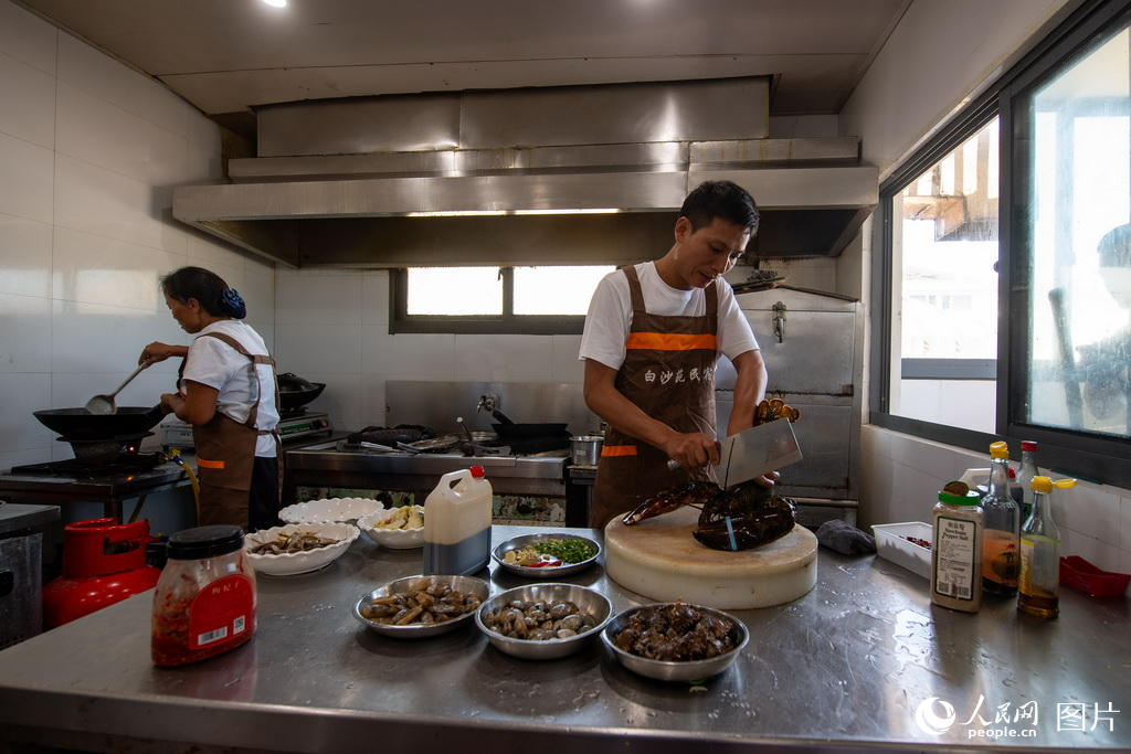 9月8日，餐館老板王教兵正在后廚為游客准備午飯。2009年退伍來到白沙島，經營餐飲業14年，如今一年的營業額能達到200萬元。