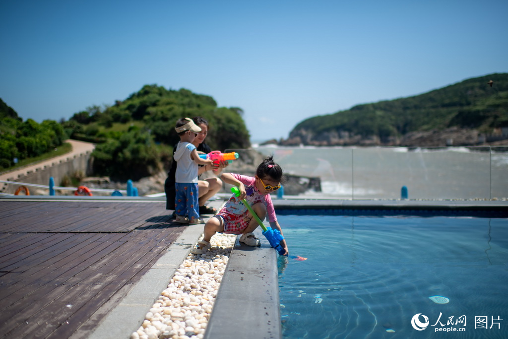 9月8日，在一民宿泳池旁，兩個孩子正在盡情玩耍。