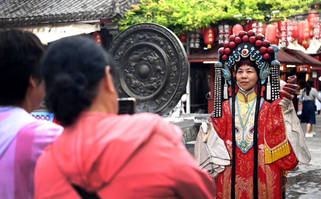 9月12日，西安市新城區“遇見城牆·非遺韻”非遺集市上，游客與秦腔戲服裝置合影。