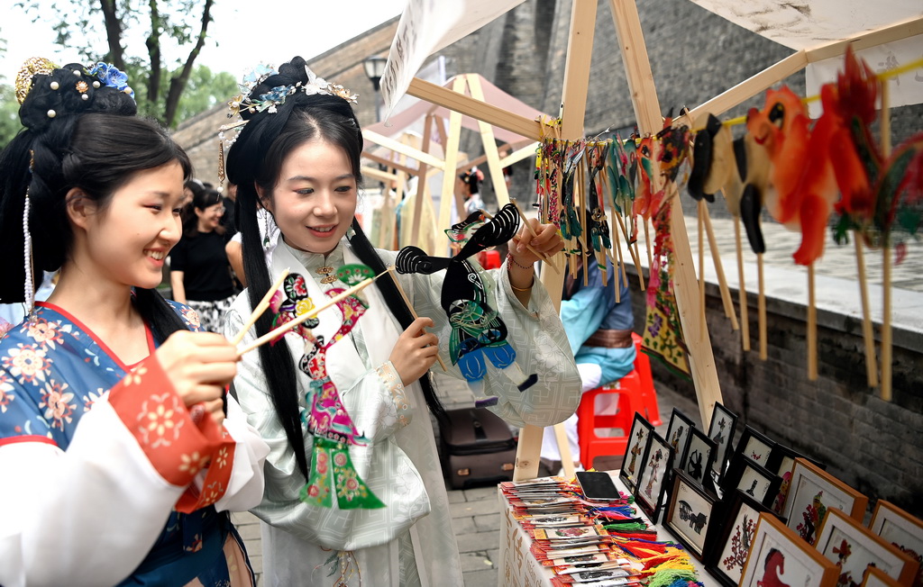 9月12日，西安市新城區“遇見城牆·非遺韻”非遺集市上，游客在了解陝西皮影。