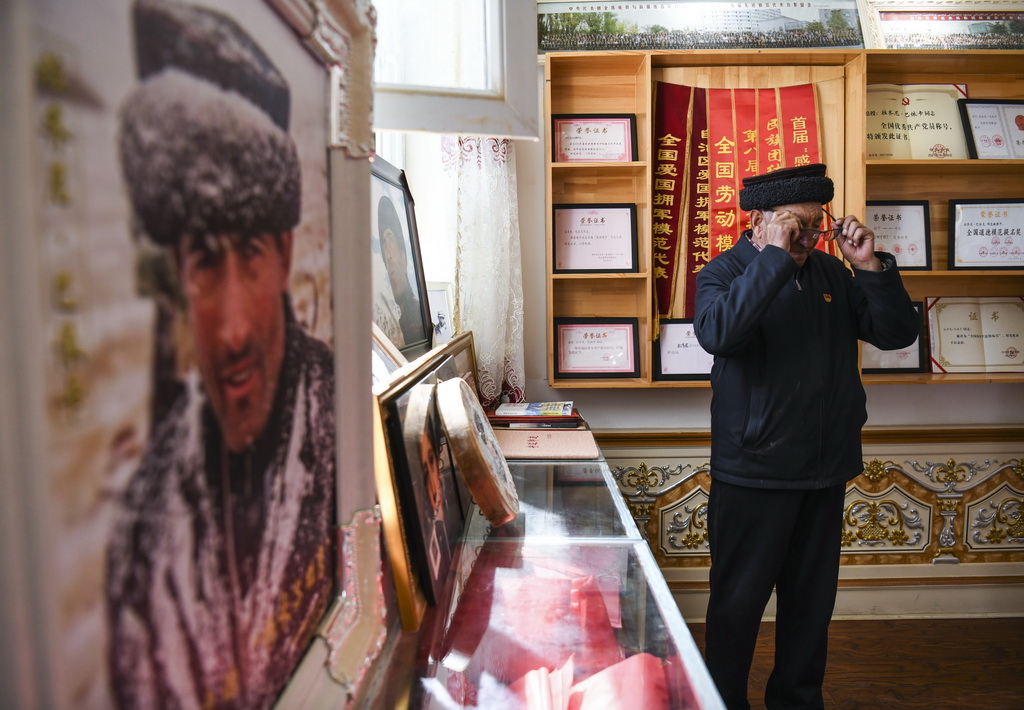  9月4日，巴依卡老人在整理兒子拉齊尼生前的照片后摘下眼鏡擦拭眼淚。新華社記者 王菲 攝
