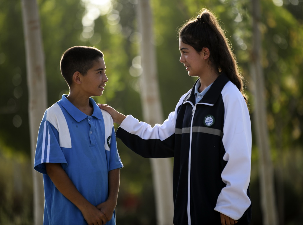 9月7日，在新疆喀什第二中學院內，拉齊尼的女兒都爾汗·拉齊尼和她的弟弟拉迪爾·拉齊尼聊天，姐姐鼓勵弟弟要好好學習。新華社記者 王菲 攝