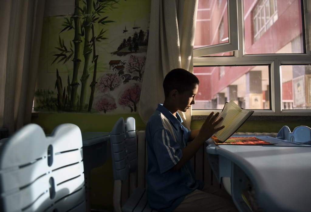 9月7日，在新疆喀什第二中學，拉齊尼的兒子拉迪爾·拉齊尼在收到老師送他的新學年禮物時，撫摸著嶄新的筆記本。新華社記者 王菲 攝