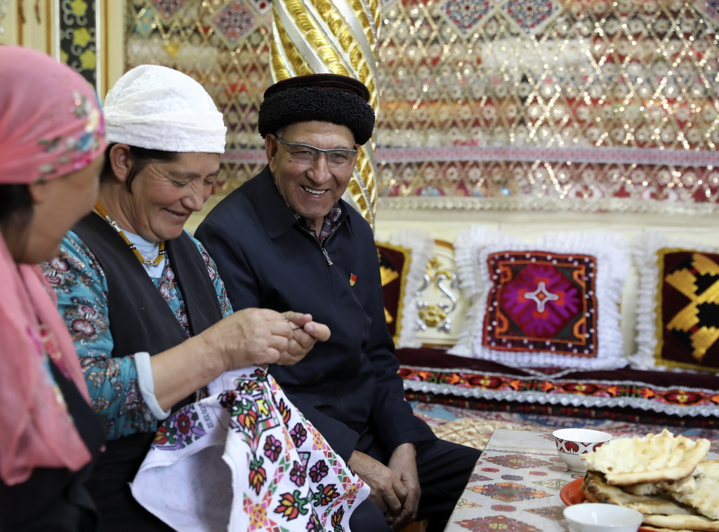 9月4日，巴依卡老人（右）在家中休息，他的老伴帕熱扎·加依克（中）在繡制靠墊套。新華社記者 程婷婷 攝