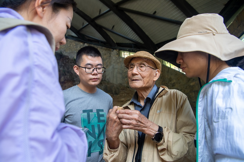 9月14日，黃萬波（右二）與考古發掘隊隊員在仔細觀察剛出土的化石。