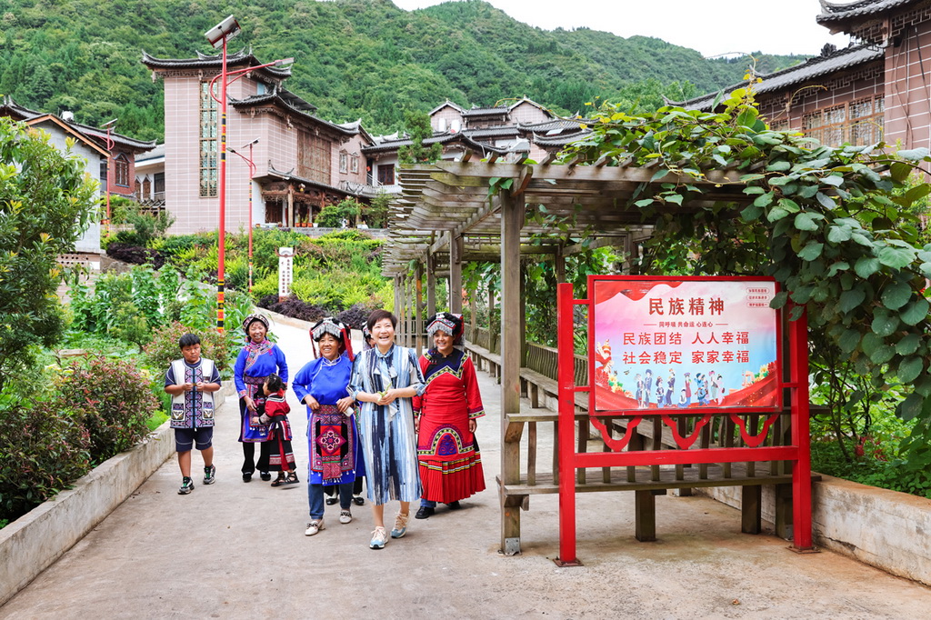 余留芬在彝族村寨與村民拉家常、講政策、話美景。鄭璐攝