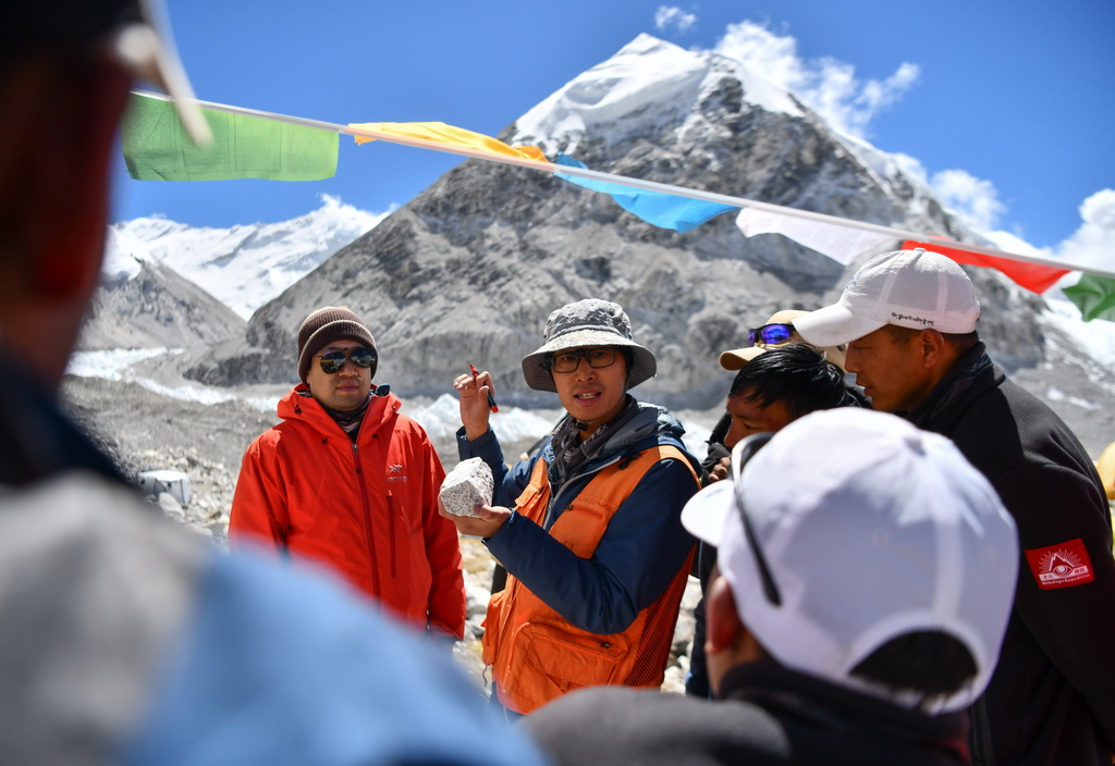 科考隊隊員劉小馳（中）在為西藏登山隊隊員講解如何採集峰頂至前進營地的岩石樣本（9月27日攝）。