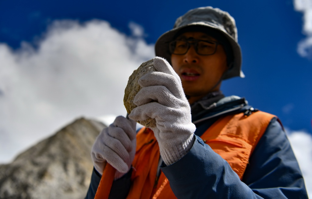 科考隊隊員劉小馳在查看岩石樣本（9月27日攝）。