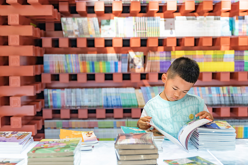 10月3日，小朋友在浙江省温州市龙湾区钟书阁书店内阅读。新华社发（刘吉利 摄）