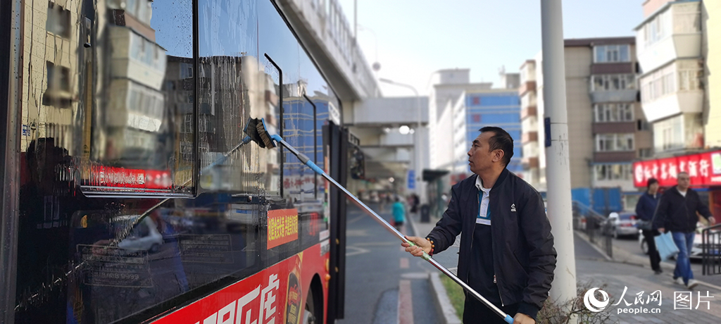 10月4日一早，吉林省長春市271路車站，司機何師傅發車前為公交車做好清潔工作，確保乘客舒心出行。人民網記者 王帝元攝