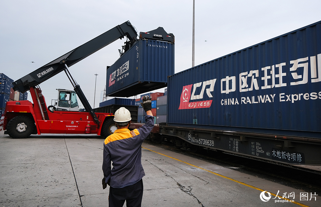 10月7日，天津港北鐵路集裝箱中心站中歐班列現場工作人員正在指揮裝車作業。