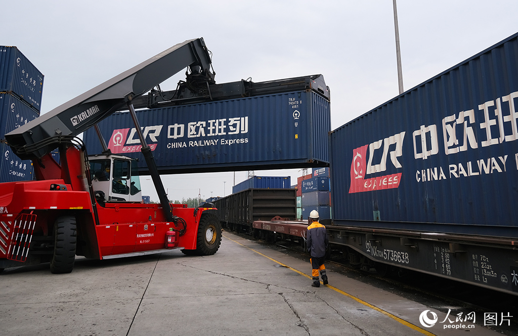 10月7日，天津港北鐵路集裝箱中心站中歐班列現場工作人員正在指揮裝車作業。