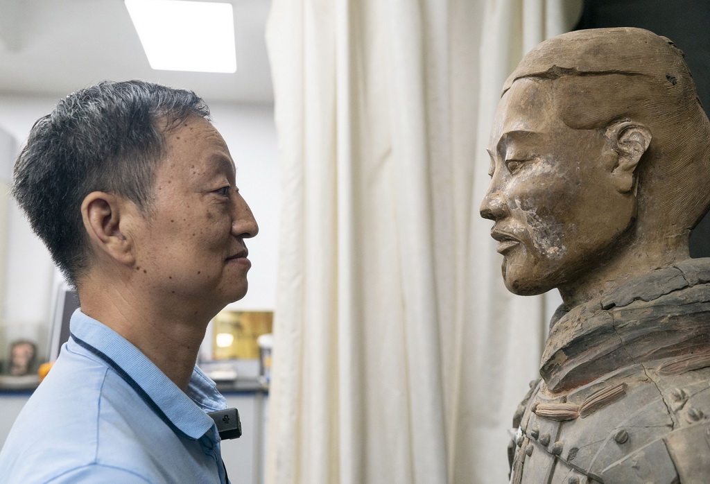 秦始皇帝陵博物院文物修復專家蘭德省在修復室內凝視一尊彩色秦俑（8月23日攝）。新華社記者 才揚 攝