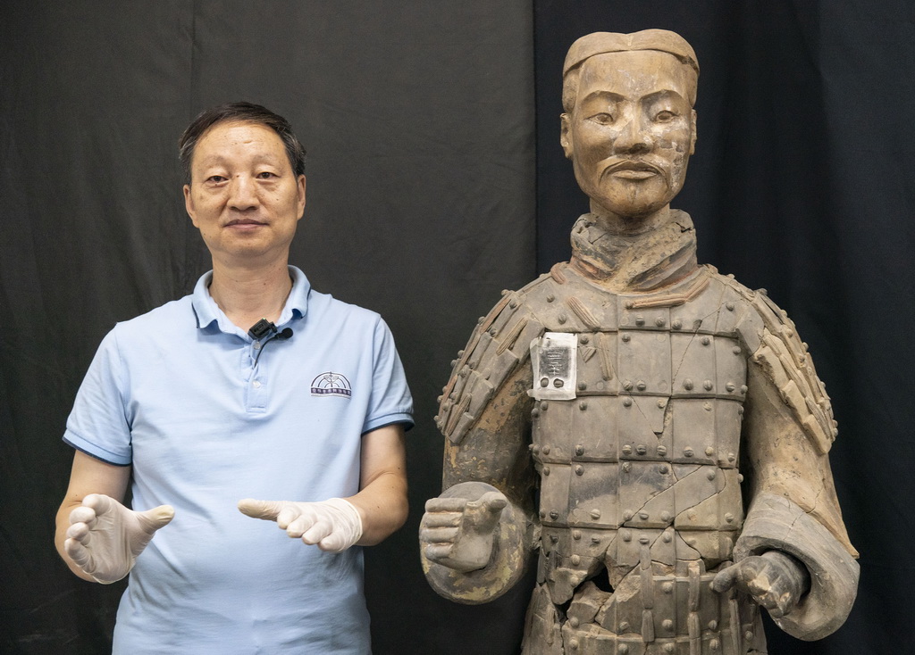 秦始皇帝陵博物院文物修復專家蘭德省在修復室內模仿一尊經修復的彩色秦俑立姿（8月23日攝）。新華社記者 才揚 攝